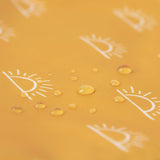 Close-up of water droplets on a yellow surface with sun designs from Bumkins SuperBib® 3 Pack: Desert Boho collection.