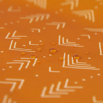 Close-up of droplets on Wet Bag: Grounded by Bumkins, highlighting the beauty of its waterproof fabric with a geometric pattern.