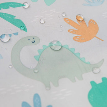 Illustration of a smiling green dinosaur on Bumkins waterproof Sleeved Bib with orange and blue leaf accents.