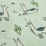 Bumkins Sleeved Bib: Llamas features illustrated llamas and cacti on mint-green. Its waterproof, with easy-clean fabric.