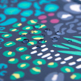 Close-up of durable fabric with water droplets on green, yellow, and blue shapes; ideal for waterproof SuperBib® by Bumkins.