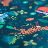 Close-up of Bumkins Wet Bag: Jungle showing water droplets on waterproof fabric with colorful jungle animal and plant illustrations.