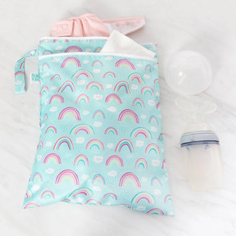 Bumkins Wet/Dry Bag: Rainbows, pink cloth diaper, breast pump, and storage bottle on white. Made from waterproof fabric.