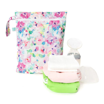 Bumkins Watercolor Wet/Dry Bag with waterproof fabric, breast pump, and cloth diapers in pink, white & green on a white background.