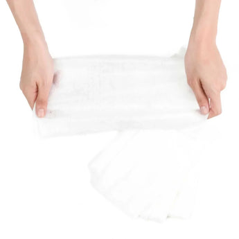 Hands holding Bumkins Diaper Liners, perfect for easy clean-up during cloth diapering sessions.