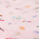 Close-up of water droplets on Bumkins Short-Sleeved Smock: Princess Magic, ideal for easy-clean with colorful Disney designs.