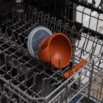 Bumkins Silicone First Feeding Set in Clay: includes baby spoon and suction lid, dishwasher safe on top rack, ideal for self-feeding.