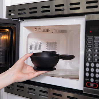 Placing Bumkins Silicone First Feeding Set in Mickey Mouse Classic Black into a microwave.