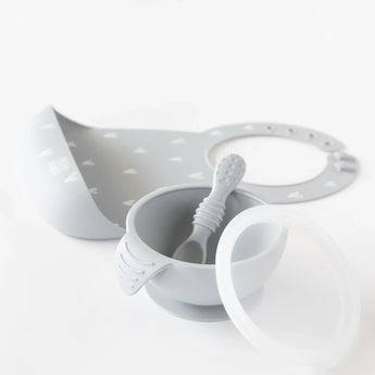 Elegant Bumkins Silicone First Feeding Set: Gray with bib, spoon, bowl, and lid arranged on a white background.