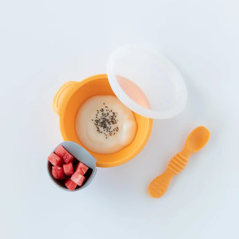 Bumkins Silicone First Feeding Set: Tangerine includes a bowl with suction base, small cup, and spoon. Perfect for yogurt and seeds!.