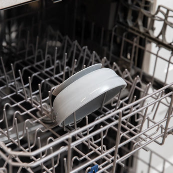 Open dishwasher with a Bumkins Silicone Grip Bowl: Gray securely placed on the rack, designed for stability during any wash cycle.