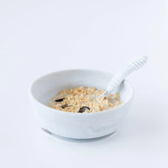 Bumkins Silicone Grip Bowl: Marble with cereal, milk, and fruit; ideal for toddlers. Comes with a spoon on a plain background.