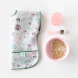 Floral baby bib, Bumkins Silicone Grip Bowl: Pink, sippy cup & spoon set artfully placed against a white backdrop.