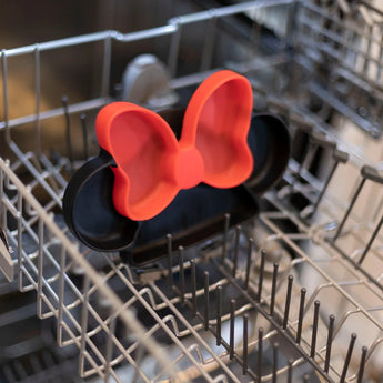 Bumkins Silicone Grip Dish: Minnie Mouse vibe sits in an open dishwasher rack, ready for its next use.