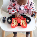 Toddler in a high chair enjoys pasta and snacks from Bumkins Silicone Grip Dish: Minnie Mouse with suction base.