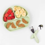 A Sage Silicone Grip Dish by Bumkins holds watermelon, banana slices, and waffles for toddlers on a white background.