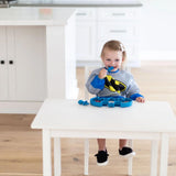 A child in a Batman Blue outfit enjoys a meal with a blue spoon, using Bumkins Silicone Grip Dish for toddlers.