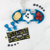 The Silicone Grip Dish: Batman Blue by Bumkins serves waffles, yogurt, and strawberries with a Bat-themed pouch and utensils nearby.