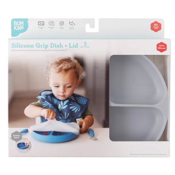 Toddler with a gray Bumkins Silicone Grip Dish (3 sections, lid) wearing a bib, next to the box highlighting product features.