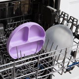 The Lavender Silicone Grip Dish with Lid by Bumkins sits in the dishwasher rack.