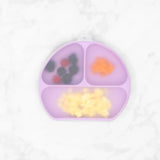 Bumkins Lavender Silicone Grip Dish has 3 sections: berries, orange mash, scrambled eggs on white marble surface. Food-safe silicone.