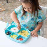 A child enjoys breakfast from a colorful Bumkins Silicone Grip Dish with Lid (5 Section): Blue while wearing an adorable animal bib.