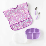 Bumkins Lavender Silicone Grip Dish with Lid, pink unicorn bib, plus fork & spoon—perfect for toddler portions.