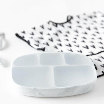 Marble Silicone Grip Dish with Lid by Bumkins, featuring 5 sections, and a patterned bib with black arrows on white.