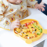 Baby enjoying strawberries and avocado from a Bumkins Disney Little Ones Gift Bundle, Winnie The Pooh dish with matching bib.