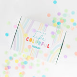 Colorful confetti surrounds a white Bumkins Ultimate Gift Set - Floral & Lace box with rainbow design, Chewtensils, and Making Life Colorful.