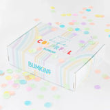 A vibrant Bumkins Ultimate Gift Set - Floral & Lace box on a white surface, surrounded by colorful confetti, features charming SuperBibs.