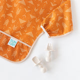 The Desert Boho Ultimate Gift Bundle by Bumkins includes a SuperBib in geometric patterns, perfect for self-feeding on a white surface.