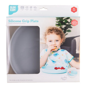 A child enjoys sliced fruit from a Bumkins Silicone Grip Plate: Gray, made of food-safe silicone with a strong suction base.