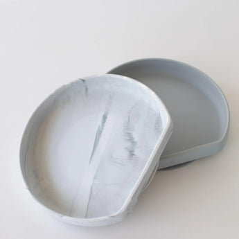 Two circular, light gray Silicone Grip Plate: Marble coasters by Bumkins are slightly stacked on a white surface.