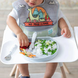 A baby in a high chair enjoys rice with peas from Bumkins Silicone Grip Plate: Marble, paired with a No Prob-llama bib.