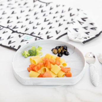 Bumkins Silicone Grip Plate: Marble with rigatoni, diced carrots, broccoli & olives. Includes bib & utensils nearby for childrens meal.