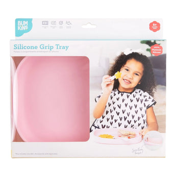 Packaging of the pink Silicone Grip Tray features a smiling child with a snack. Made from food-safe silicone, branded Bumkins.