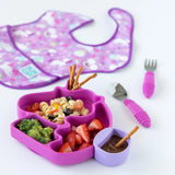 Bumkins unicorn plate with pasta salad, strawberries, broccoli, and chocolate dip in Silicone Little Dipper: Lollipop. Purple bib/utensils nearby.