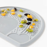 Bumkins Silicone Sensory Placemat in Gray has textured sections for holding diced fruits, ideal for mealtime sensory play.