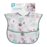 A smiling baby wears the Bumkins SuperBib®: Floral, waterproof with a floral pattern and green trim.