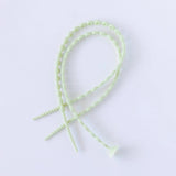 Two intertwined Bumkins Silicone Accessory Tether pieces, sage color with a beaded design on white. Comes in a 2-pack.