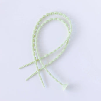 Two intertwined Bumkins Silicone Accessory Tether pieces, sage color with a beaded design on white. Comes in a 2-pack.