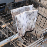 Bumkins Reusable Snack Bags (Large 2-Pack: XOXO & Hearts) are upright in an open dishwasher, showcasing their waterproof fabric.