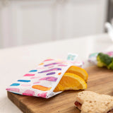 Bumkins Reusable Snack Bag, Small 2-Pack: Watercolor & Brush Strokes shown with sandwich and broccoli on a wooden board. Machine washable.