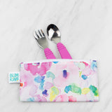 Bumkins Reusable Snack Bag in Watercolor design holds a pink-handled spoon and fork, crafted from waterproof fabric on white marble.