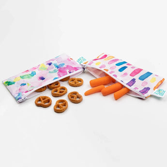 Bumkins Reusable Snack Bag 2-Pack in Watercolor & Brush Strokes on white, filled with pretzels and carrots. Machine washable!.