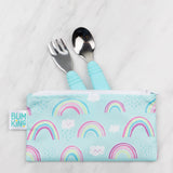 Bumkins Reusable Snack Bag in Rainbows & Unicorns holds a toddler fork/spoon. Waterproof and vibrant with blue handles on marble.