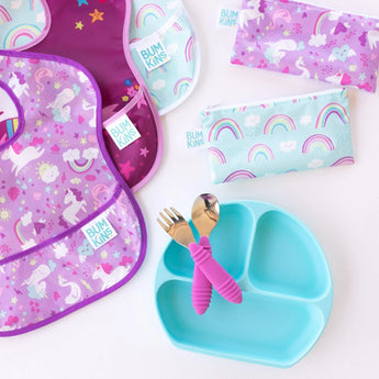 Bumkins Reusable Snack Bags, Rainbows & Unicorns: Includes a divided plate and pink utensils on waterproof fabric background.