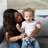 A woman and toddler with snacks in Bumkins’ Super Mario™ Reusable Snack Bags. Wall art and cushions add a charming touch.