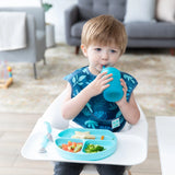 A child in a Bumkins Blue Silicone Straw Cup drinks independently, mastering skills while sitting in a high chair with food.